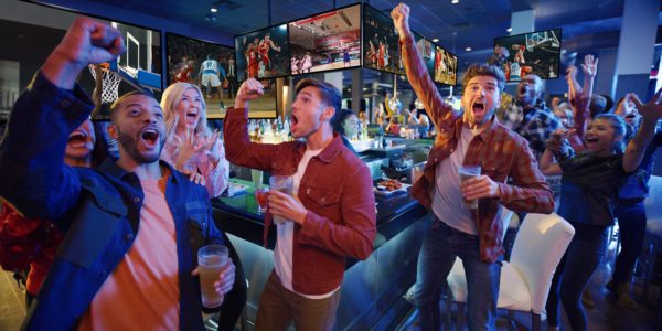 Group of friends cheering on a game at Dave and Busters